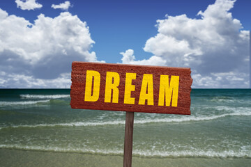 Dream text on a sign at a beautiful beach for the concept of live the life of your dreams.