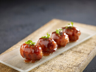Deep-fried Cheese Bacon Roll served in a dish isolated on wooden board side view dark background