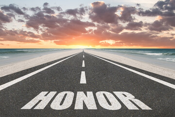Honor written on a highway road at sunset at the beach.