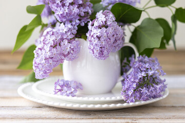 Beautiful spring composition with lilac flowers in a white cup for countryside decor