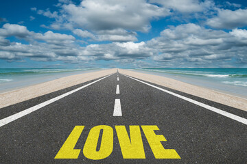 The word Love on a beautiful highway leading to infinity.