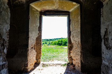 Exit from the old ruined building with thick walls. View from the exit of the castle on the picturesque landscape