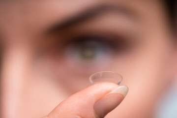 Woman Holding Contact Lens In Her Finger