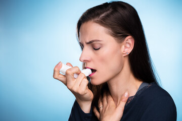 Woman With Asthma Using An Asthma Inhaler - obrazy, fototapety, plakaty