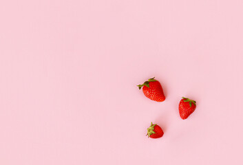Fresh red strawberry on pink background, top view. Minimalistic scattered berries pattern. Creative...