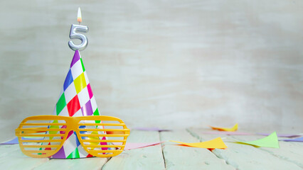 A creative birthday card for a five-year-old child, a candle with the number five, congratulations,...