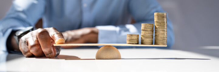 Businessman Balancing Stacked Coins With Finger
