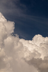 Cumulus clouds in a dark blue sky before a thunderstorm.
