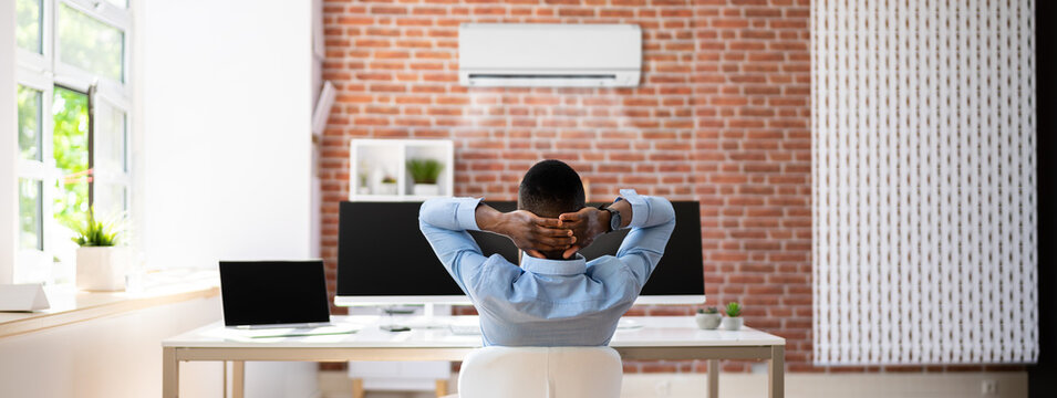 Businessman Relaxing In Office With Air Conditioning