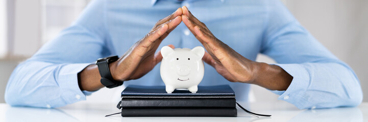 African American Male Protecting Piggy Bank