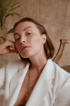 portrait of a beautiful woman in a white jacket with beautiful jewelry on her neck