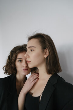 Portrait Of Two Girls In Black Clothes On A White Background In A Bright Studio