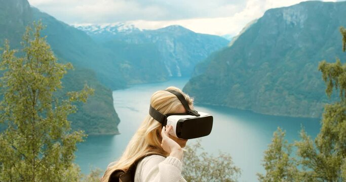4k video footage of a young woman using a virtual reality headset while exploring Mre og Romsdal