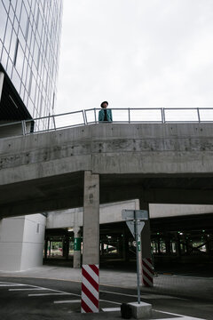 photo of a girl with bright clothes and a hat standing on the second level of the parking lot