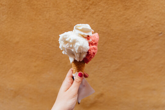 Woman holds a gelato in her left hand