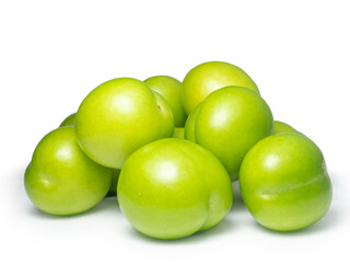 Green cherry plum on a white background. Fruit for making tkemali sauce. Useful fruit.