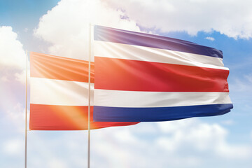 Sunny blue sky and flags of costa rica and austria