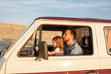 Girl learning to drive vehicle with dad