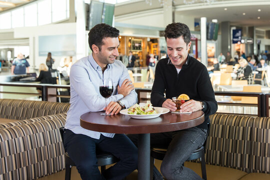 Two Men Enjoy a Pre-Flight Beverage at an Airport