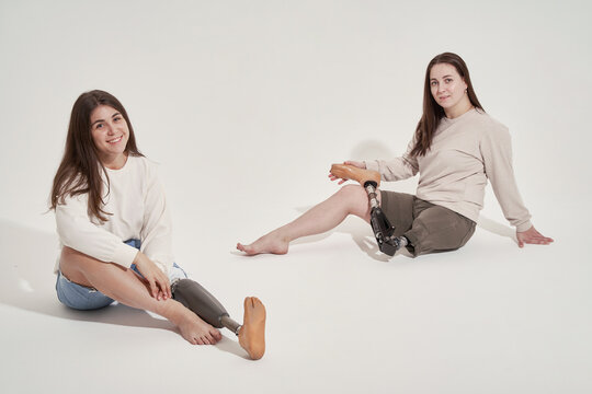 Positive women with prosthetic leg sitting together