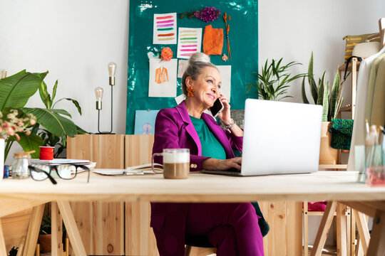 Chic senior woman making phone call at office