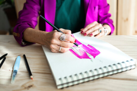 Female hands drafting suit jacket on sketch book
