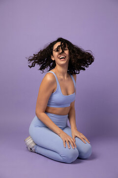 Woman Flips Hair Happily in Monochromatic Studio Portrait