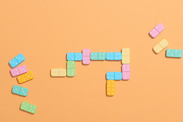 Dominoes. Colorful domino chips lay on a beige background
