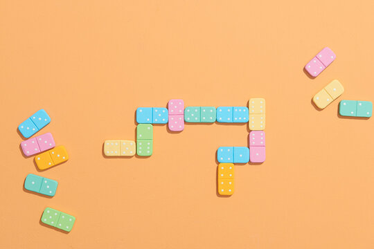 Dominoes. Colorful domino chips lay on a beige background