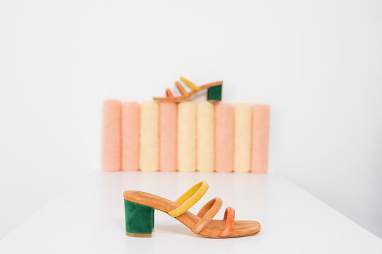 strappy colored shoes still life on pastel colored cylinder props
