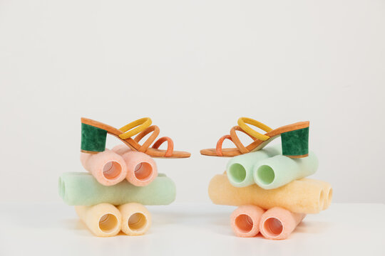 strappy colored shoes still life on pastel colored cylinder props