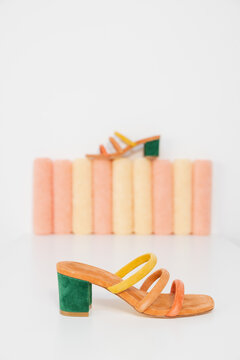 strappy colored shoes still life on pastel colored cylinder props