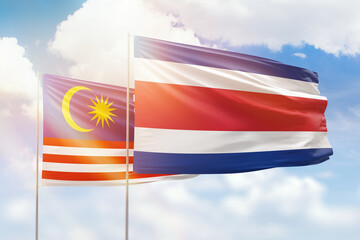 Sunny blue sky and flags of costa rica and malaysia