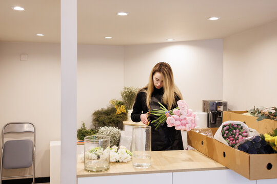 Florist cutting away stems in peonies 
