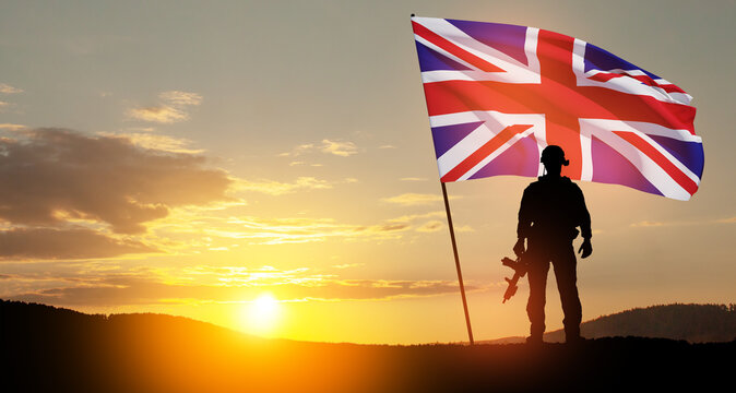 Silhouette of soldier with United Kingdom flag on background of sunset. Greeting card for Poppy Day, Remembrance Day. United Kingdom celebration. - Powered by Adobe