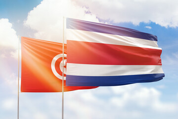 Sunny blue sky and flags of costa rica and tunisia