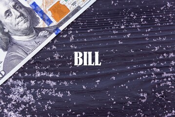 Fototapeta na wymiar BILL - word (text) on a dark wooden background, money, dollars and snow. Business concept (copy space).