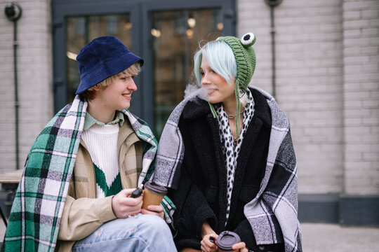 Lesbian couple having coffee break outside 