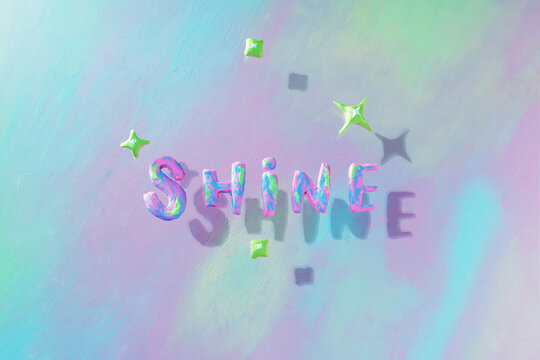 Shine. Handmade clay word on colorful background with stars