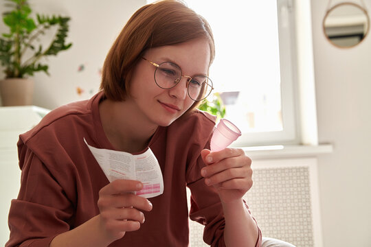 Teenage girl studying the instructions for the menstrual cup