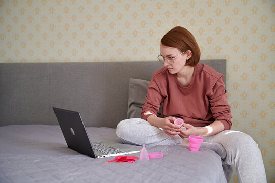 A teenager looks at the instructions for the menstrual cup on a laptop