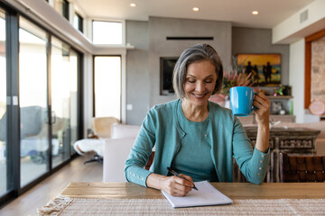 Woman Drinking Coffee Jots Down Her Ideas