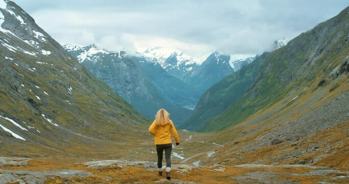 4k video footage of an unrecognisable woman standing and taking photos on her cellphone of mountains in Stryn