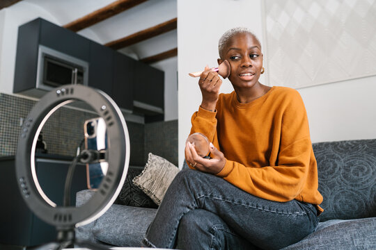 Positive influencer applying face powder