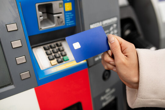 Person Holds Card In Front Of Gas Pump