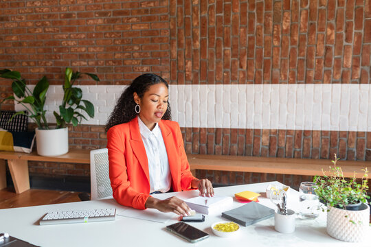 Mixed manager on fluor blazer working at office desk