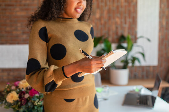 Happy woman taking notes at work