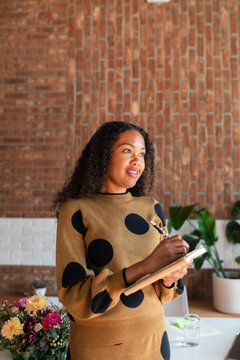 Young woman taking notes standing in office