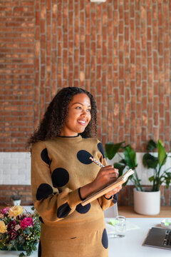 Elegant woman taking notes standing in office