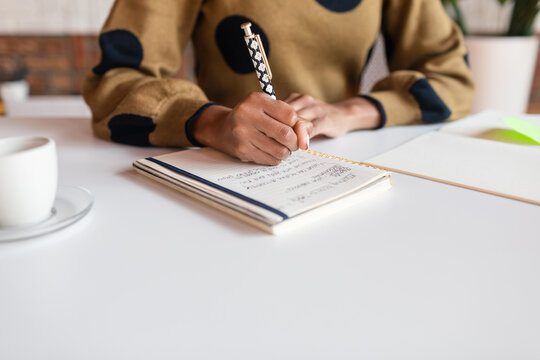 Cropped executive taking notes at desk